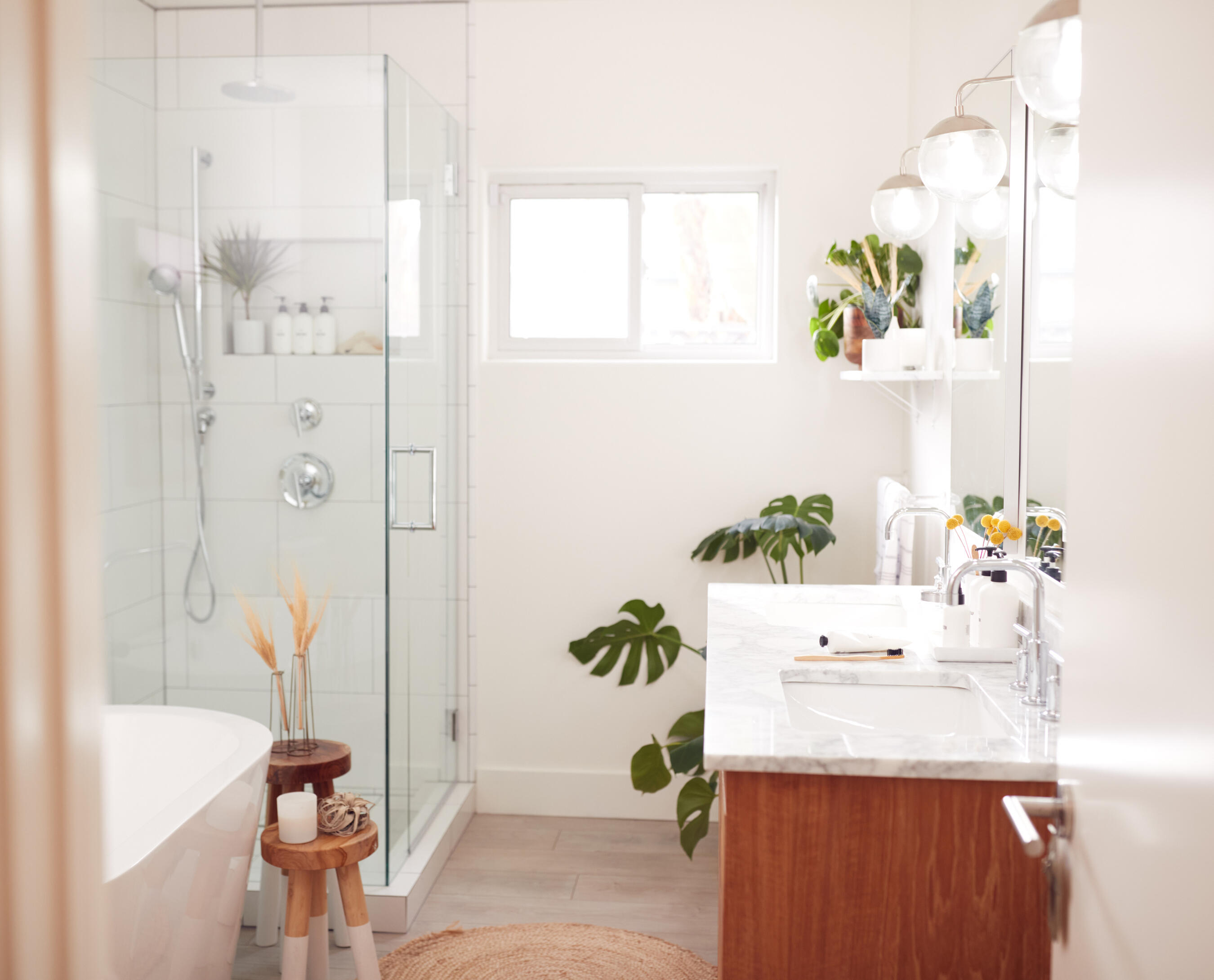 A house roof with two dormer windows featuring arches and white shutters, covered with gray shingles.