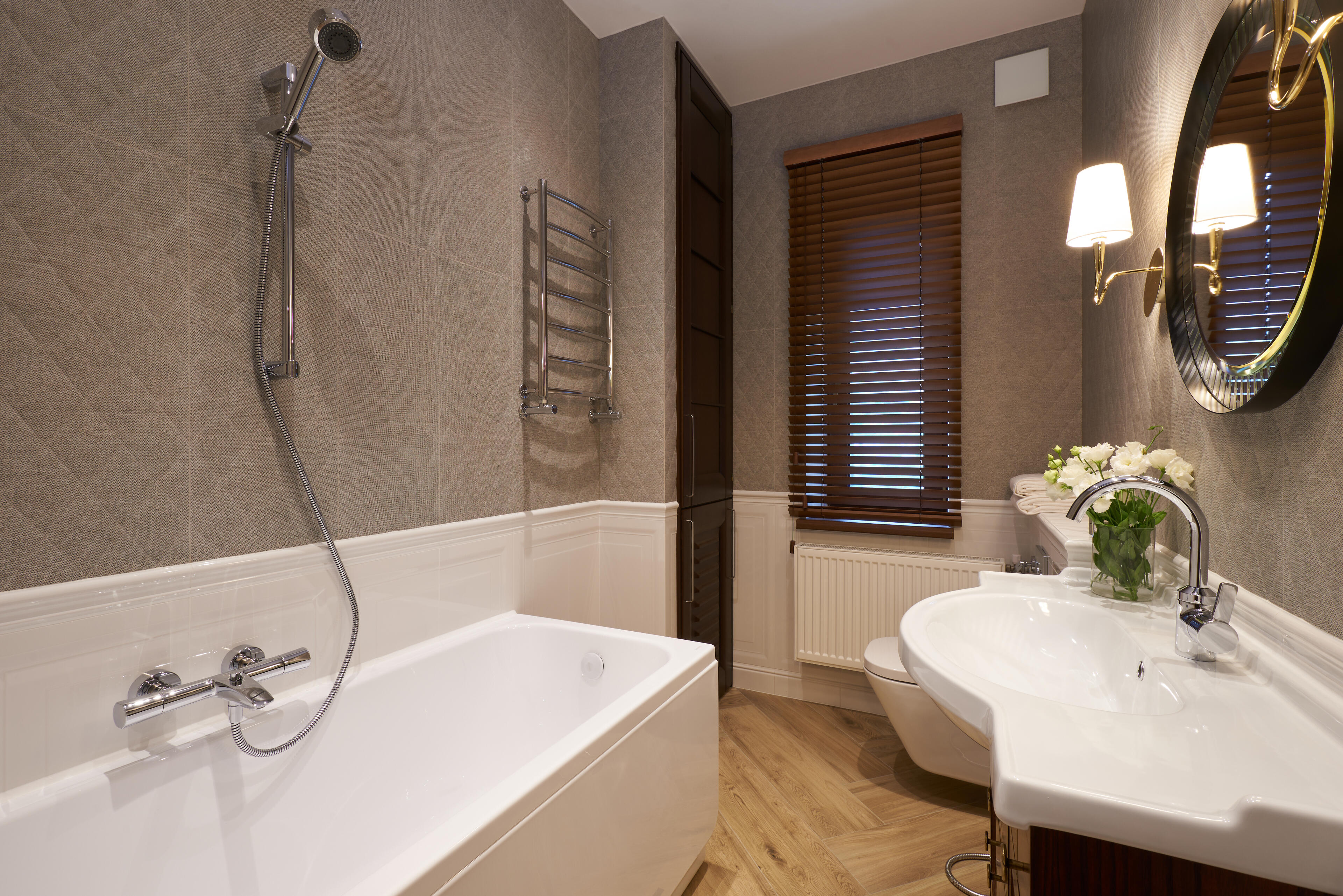 Close-up of a shingled roof with a background of house rooftops and sky.